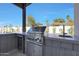Outdoor kitchen featuring a built-in grill, beverage fridge, and concrete countertops at 6126 E Charter Oak Rd, Scottsdale, AZ 85254