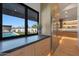 Kitchen view showcasing the outdoor pool and entertaining space through a large window at 6126 E Charter Oak Rd, Scottsdale, AZ 85254
