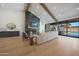 Modern living space with a stone fireplace, beamed ceilings, and sliding glass doors to the pool area at 6126 E Charter Oak Rd, Scottsdale, AZ 85254