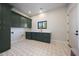 Mud room features granite countertops, dark green cabinets, decorative floor tiles and window at 6126 E Charter Oak Rd, Scottsdale, AZ 85254