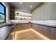 Spacious walk-in pantry with custom cabinets, stone countertops, and a sink by the window at 6126 E Charter Oak Rd, Scottsdale, AZ 85254