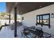 Outdoor patio with a built-in grill, dining area, and view of the backyard and kitchen window at 6126 E Charter Oak Rd, Scottsdale, AZ 85254