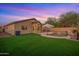 A beautiful backyard is complemented by a freeform pool with a rock waterfall and lush green turf perfect for relaxation at 6309 W Hughes Dr, Phoenix, AZ 85043