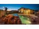 Backyard with a beautiful rock-feature pool, string lights, and a covered patio for relaxing evenings at 6309 W Hughes Dr, Phoenix, AZ 85043