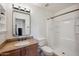 This bathroom has wood vanity, granite countertop, framed mirror, and shower with a tub at 6309 W Hughes Dr, Phoenix, AZ 85043