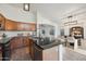 Spacious kitchen with wood cabinets, dark countertops, stainless steel appliances, and a breakfast bar at 6309 W Hughes Dr, Phoenix, AZ 85043