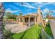 Lush backyard with artificial grass, outdoor kitchen, covered patio, swimming pool and play structure at 6713 E Paradise Ln, Scottsdale, AZ 85254