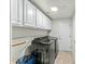 Well-organized laundry room with overhead cabinets, modern washer and dryer, and convenient storage solutions at 6713 E Paradise Ln, Scottsdale, AZ 85254