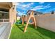 Backyard playground featuring a slide and swings on a well-maintained artificial turf lawn at 6713 E Paradise Ln, Scottsdale, AZ 85254