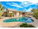 Backyard pool featuring travertine tile surround, covered patio, and secure fencing for safety at 6713 E Paradise Ln, Scottsdale, AZ 85254
