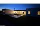 Backyard view of a modern home with pool, patio, and outdoor lighting at dusk at 7001 E Joan De Arc Ave, Scottsdale, AZ 85254