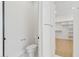 Bathroom featuring a toilet and a glimpse of a walk-in closet with custom shelving and hardwood flooring at 7001 E Joan De Arc Ave, Scottsdale, AZ 85254