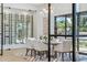 Elegant dining room featuring a glass-enclosed wine cellar, modern lighting, and stylish decor at 7001 E Joan De Arc Ave, Scottsdale, AZ 85254