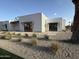 Daytime view of the modern home's exterior with desert landscaping, brick accents, and awnings at 7001 E Joan De Arc Ave, Scottsdale, AZ 85254