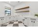 Laundry room with marble countertops, a checkered floor, wooden shelves, and backyard views at 7001 E Joan De Arc Ave, Scottsdale, AZ 85254