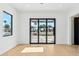 Bright living room with light hardwood floors and a large glass door leading to the front yard at 7001 E Joan De Arc Ave, Scottsdale, AZ 85254