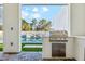 Contemporary outdoor kitchen overlooking the pool and lounge area at 7001 E Joan De Arc Ave, Scottsdale, AZ 85254