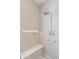 Bright shower with vertical tiles, built-in shelf lighting, a bench, and chrome shower fixture with body jets at 7001 E Joan De Arc Ave, Scottsdale, AZ 85254