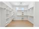 Spacious walk-in closet with custom shelving, hardwood flooring, recessed lighting, and natural light at 7001 E Joan De Arc Ave, Scottsdale, AZ 85254