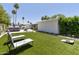 Spacious backyard with manicured lawn, outdoor seating, and mature palm trees creating a serene oasis at 7020 E Friess Dr, Scottsdale, AZ 85254