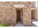 Close-up of the entry, showcasing stone accents, stylish exterior lighting, and a welcoming walkway at 7445 E Eagle Crest Dr # 1111, Mesa, AZ 85207