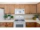 Kitchen featuring light wood cabinets, white appliances, and light countertops at 7445 E Eagle Crest Dr # 1111, Mesa, AZ 85207