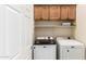 Laundry room featuring a front-loading washer, dryer, and upper wooden cabinets at 7445 E Eagle Crest Dr # 1111, Mesa, AZ 85207