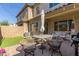 Backyard featuring a covered patio with an umbrella table and artificial grass at 754 E Harper St # 102, Gilbert, AZ 85297