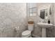 Charming powder room features patterned wallpaper, pedestal sink, and stylish mirror at 754 E Harper St # 102, Gilbert, AZ 85297