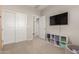 Spacious bedroom featuring white doors, carpet flooring, and a mounted TV at 754 E Harper St # 102, Gilbert, AZ 85297