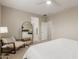 Neutral bedroom with a relaxing chair, full length mirror, and adjoining bathroom and closet at 754 E Harper St # 102, Gilbert, AZ 85297