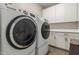Convenient laundry room is equipped with washer, dryer, white cabinets, and sleek countertops at 754 E Harper St # 102, Gilbert, AZ 85297