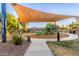 Community playground with a large sunshade, green slide and seating area at 754 E Harper St # 102, Gilbert, AZ 85297