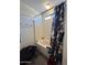 Neutral bathroom featuring a shower and tub with blue and grey shower curtain at 7664 W Vermont Ave, Glendale, AZ 85303