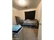 This carpeted bedroom has basic furnishings and neutral-colored walls at 7664 W Vermont Ave, Glendale, AZ 85303