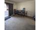 Cozy living room featuring a large window, carpet floors, and a sliding door for natural light at 7664 W Vermont Ave, Glendale, AZ 85303