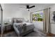 Bright bedroom boasts a ceiling fan and view of the outdoors at 8317 E Orange Blossom Ln, Scottsdale, AZ 85250