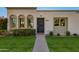 Inviting front with arched windows, a secure decorative front door, and lush grass at 8317 E Orange Blossom Ln, Scottsdale, AZ 85250