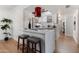 Kitchen with white cabinets, a breakfast bar, and wood floors at 8317 E Orange Blossom Ln, Scottsdale, AZ 85250