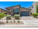 Charming home featuring desert landscaping, modern windows, and a gray two-car garage at 939 E Paseo Way, Phoenix, AZ 85042