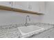 Close up of a white sink and a granite countertop with white cabinets above and below at 939 E Paseo Way, Phoenix, AZ 85042