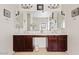 Bathroom featuring double vanity with dark wood cabinets and a large mirror at 9722 S 45Th Ave, Laveen, AZ 85339