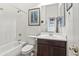 A white bathroom featuring a shower-tub combo, a dark wood vanity, and white toilet at 9722 S 45Th Ave, Laveen, AZ 85339