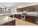 Traditional kitchen with dark wood cabinets, stainless steel appliances, and tiled flooring at 9722 S 45Th Ave, Laveen, AZ 85339
