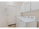 Well-equipped laundry room with washer, dryer, and overhead cabinets for storage at 9722 S 45Th Ave, Laveen, AZ 85339