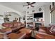 Comfortable living room with leather furniture, built-in shelving, a fireplace, and an open floorplan at 9722 S 45Th Ave, Laveen, AZ 85339