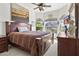 A well-lit main bedroom featuring a dark wood bed frame, neutral carpet, and bright windows at 9722 S 45Th Ave, Laveen, AZ 85339