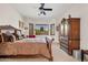 View of a bedroom with a large wooden sleigh bed, dresser, wardrobe and natural light at 9722 S 45Th Ave, Laveen, AZ 85339