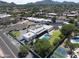 Aerial view of the modern property with a pool, solar panels and professionally landscaped yard with tennis courts at 10024 N 61St Pl, Paradise Valley, AZ 85253