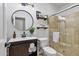 Beautiful bathroom featuring a wood vanity, round mirror, and tiled glass shower enclosure at 10024 N 61St Pl, Paradise Valley, AZ 85253